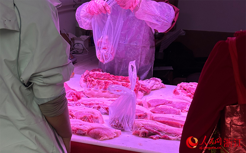 11月8日，杭州市上城区杨柳郡园四区沿街一家“农家土猪肉”店内透出紫红色灯光。人民网记者 叶宾得摄
