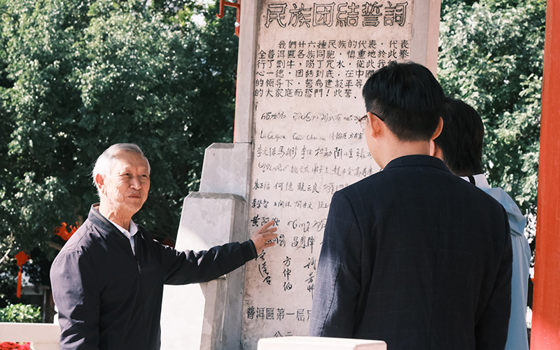 宣讲团在民族团结誓词碑前与鲁国华老师交流。学校供图
